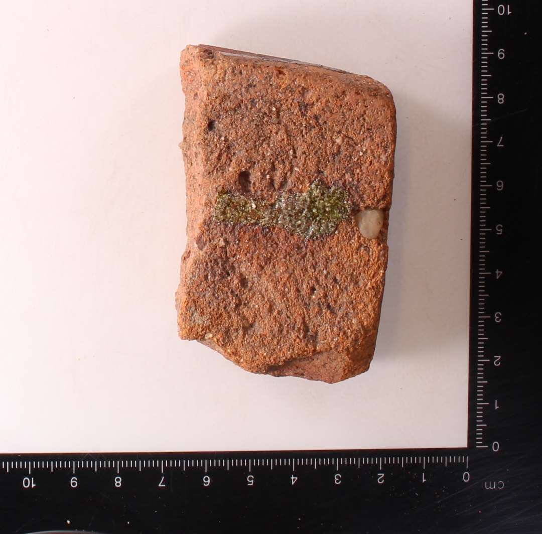 Fragmenteret gulvflise med glasurrester. tykkelse: ca 3 cm.