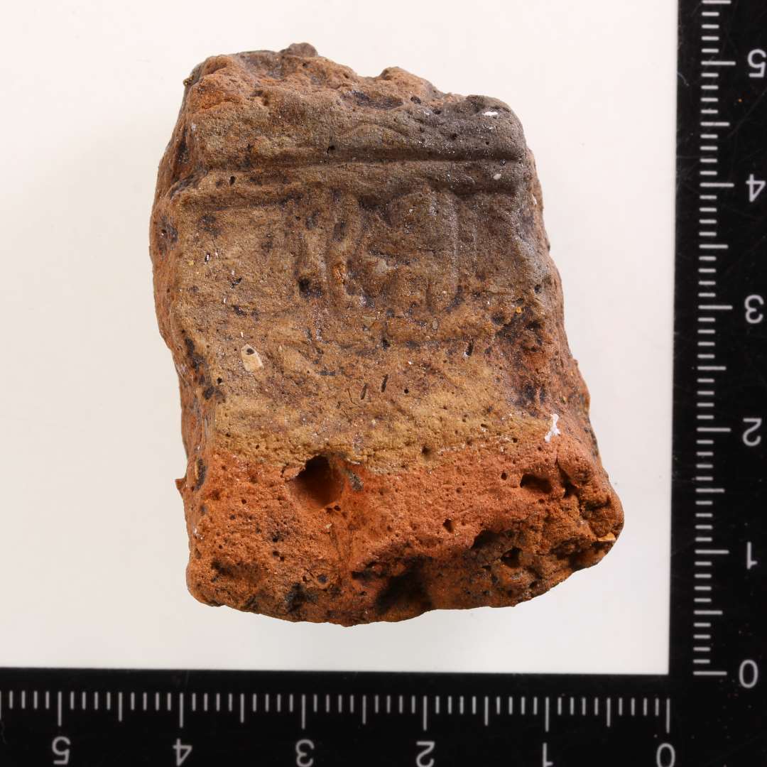 St�beformsfragment. Aftryk af sk�lformet sp�nde, ukendt type. Rygfelt med rygdyr. Gr�