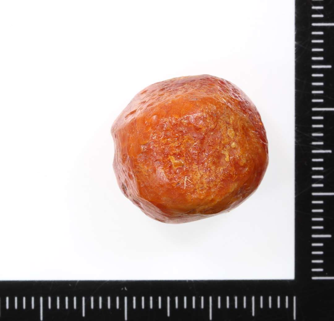 Spillebrik af rav. Uregelm�ssig halvkugleformet facon