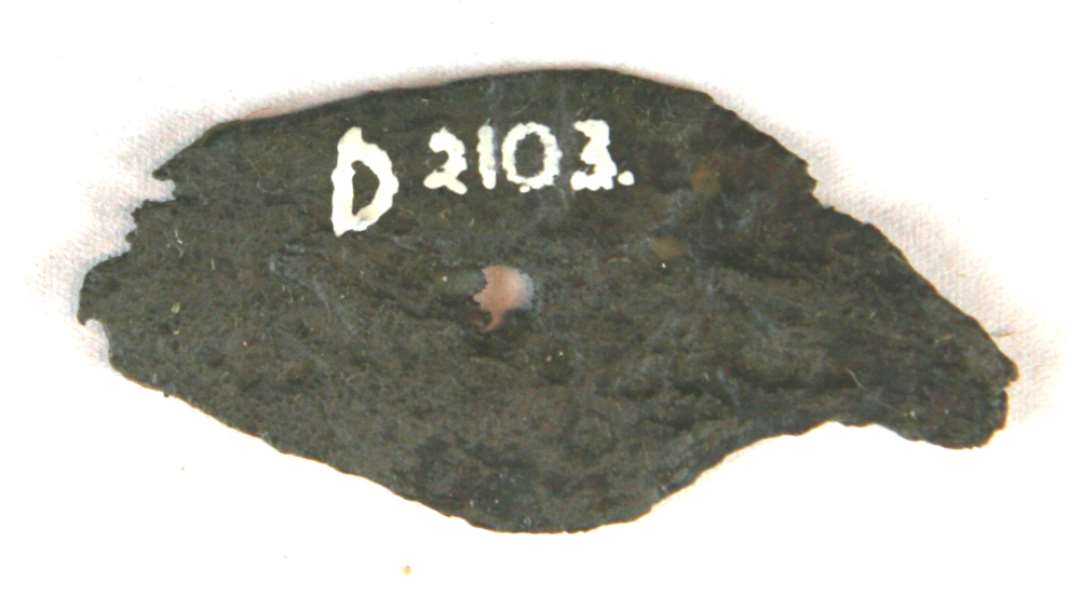 1 fladt forrustet stykke jern af uregelm�ssig form med st�rre og mindre tilspidsning mod enderne. St�rste l�ngde: 6 cm. Bredde: ca. 3 cm. Tykkelse: ca. 1,5 cm.