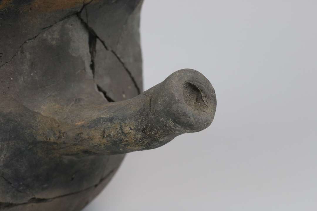 En n�sten hel jydepotte, ca. 20 cm h�j. Mangler en t� og en del af bugen.�