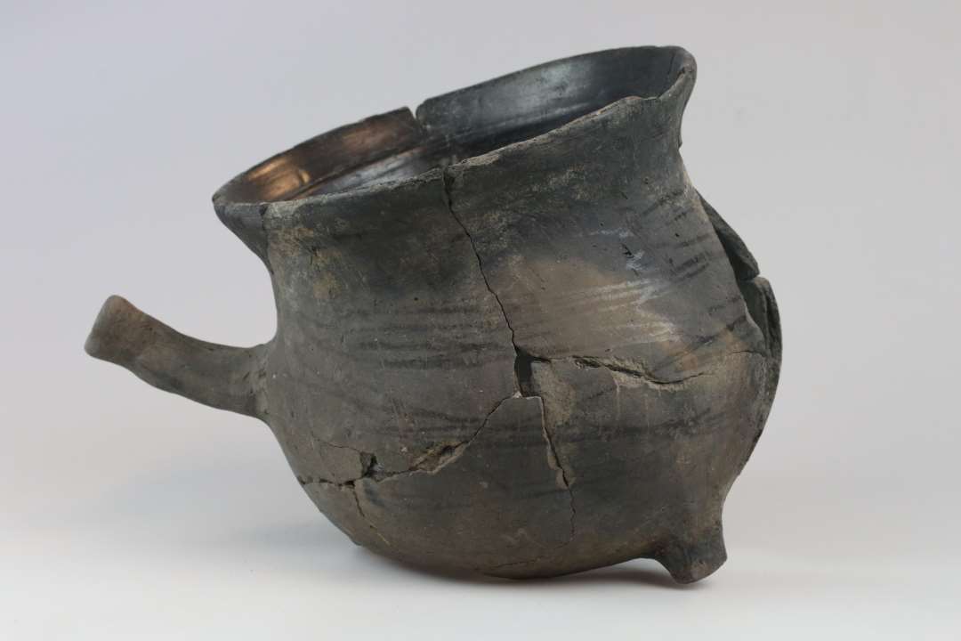 En n�sten hel jydepotte, ca. 20 cm h�j. Mangler en t� og en del af bugen.�