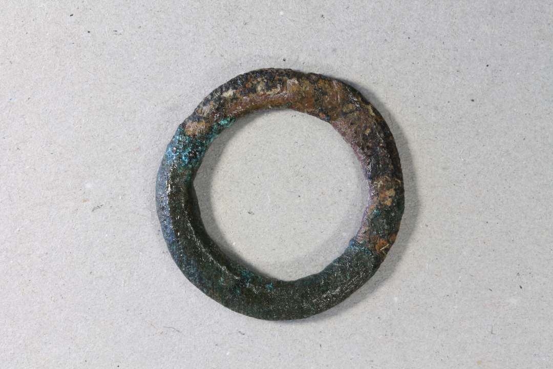  ringsp�nde. Kons.��Bronzering, � 3 cm dannet af en 4 mm bred bronzeskinne m. facetteret tv�rsnit. Kan v�re til et ringsp�nde, men mangler indsn�vringen til tornen. 
