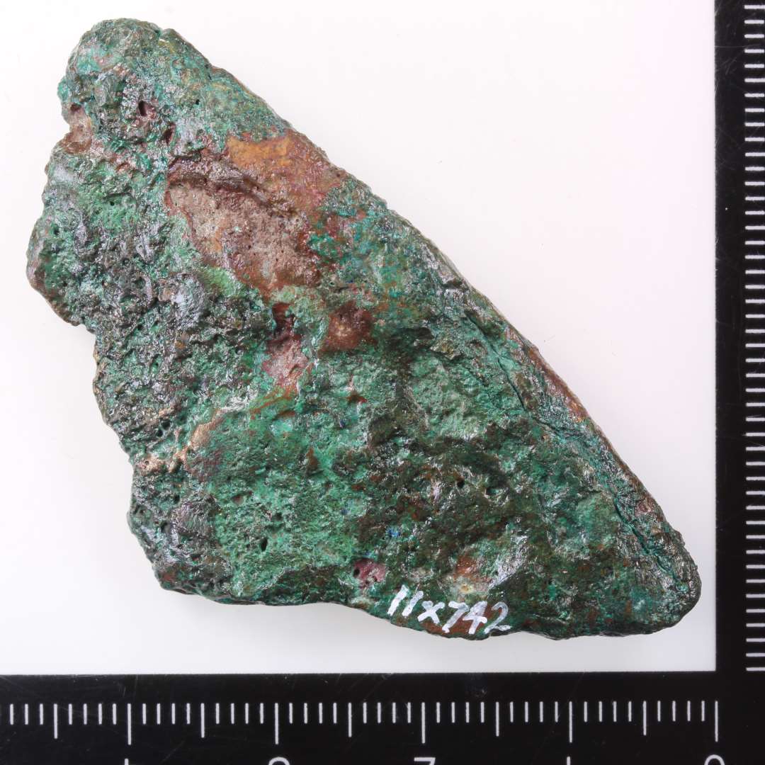 fragment af malmgryde. Kons.��Randsk�r, l. 5,5 cm.