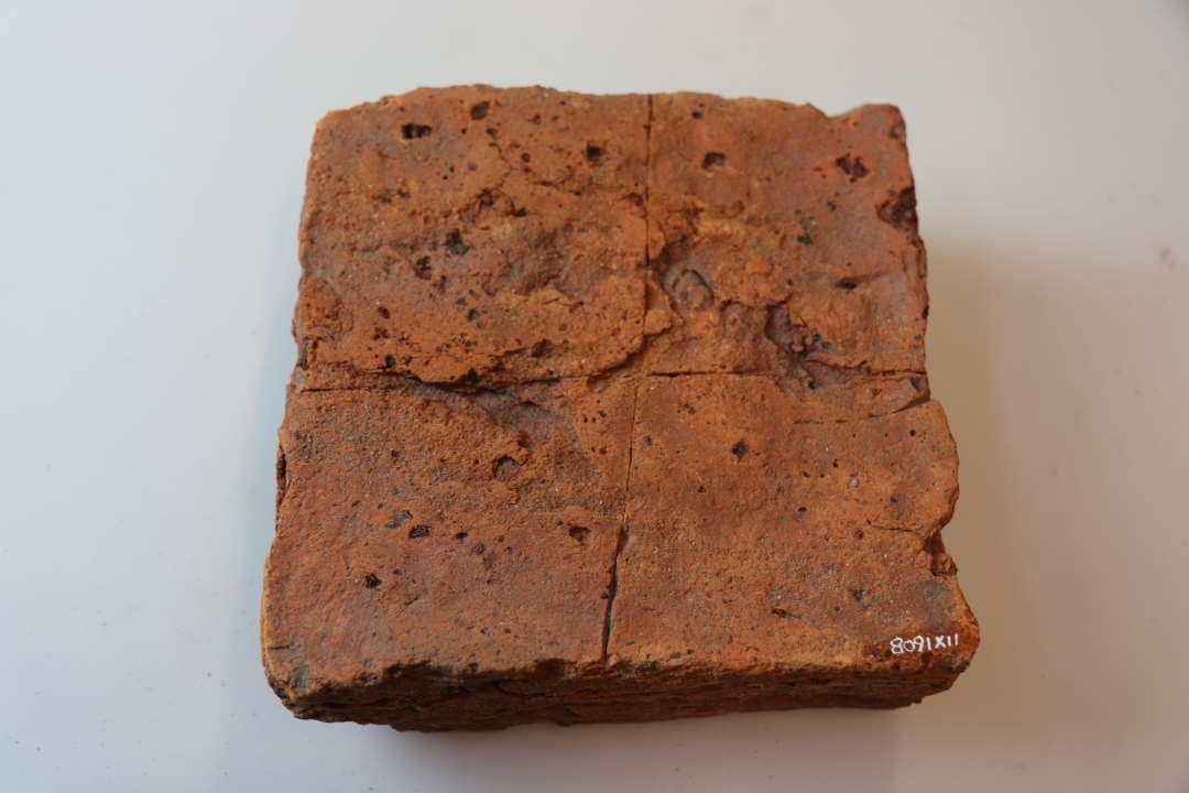 Kvadratisk flise, ca.16 x16 x 7 cm. Med indridset kryds. 