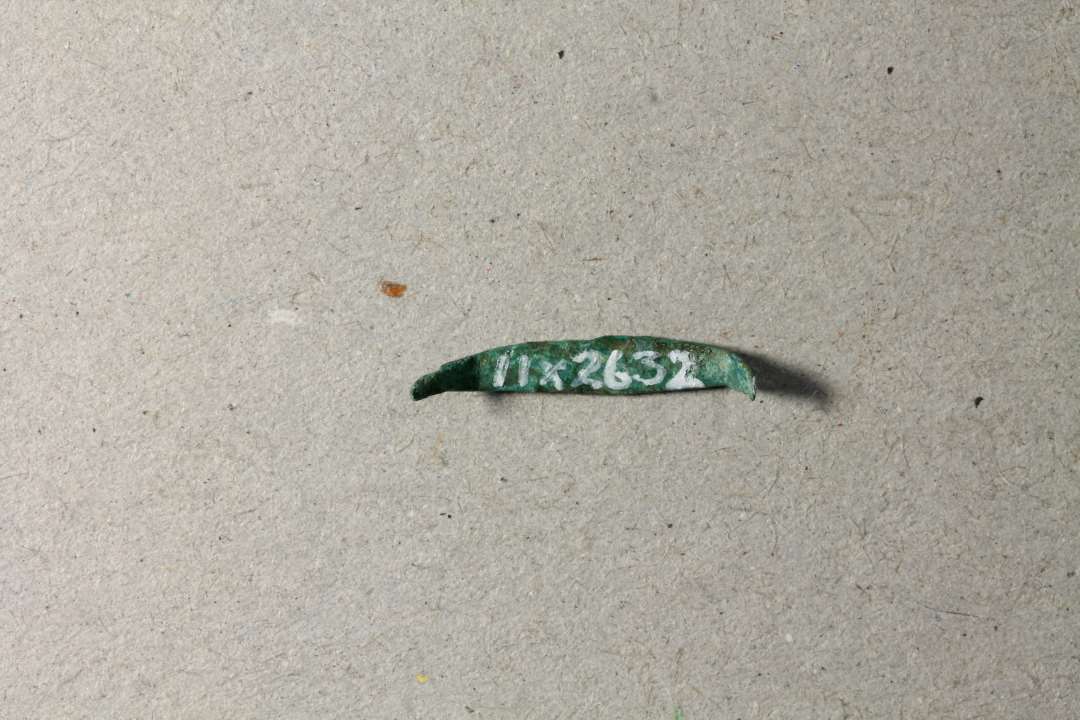 Krampe. Lakeres.��Meget lille pyntebeslag i form af en krampe, l. 1,2 cm