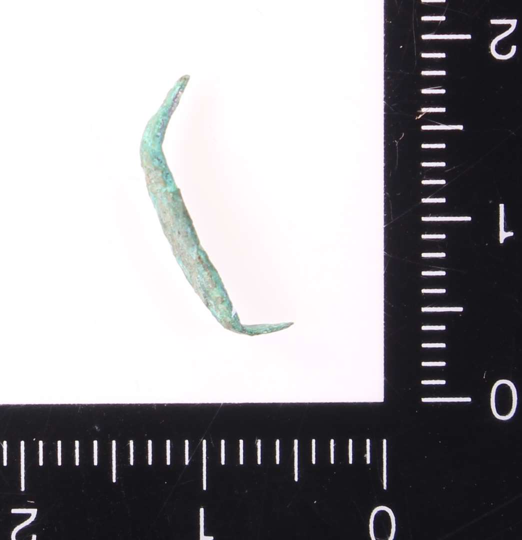 Krampe. Lakeres.��Meget lille pyntebeslag i form af en krampe, l. 1,2 cm