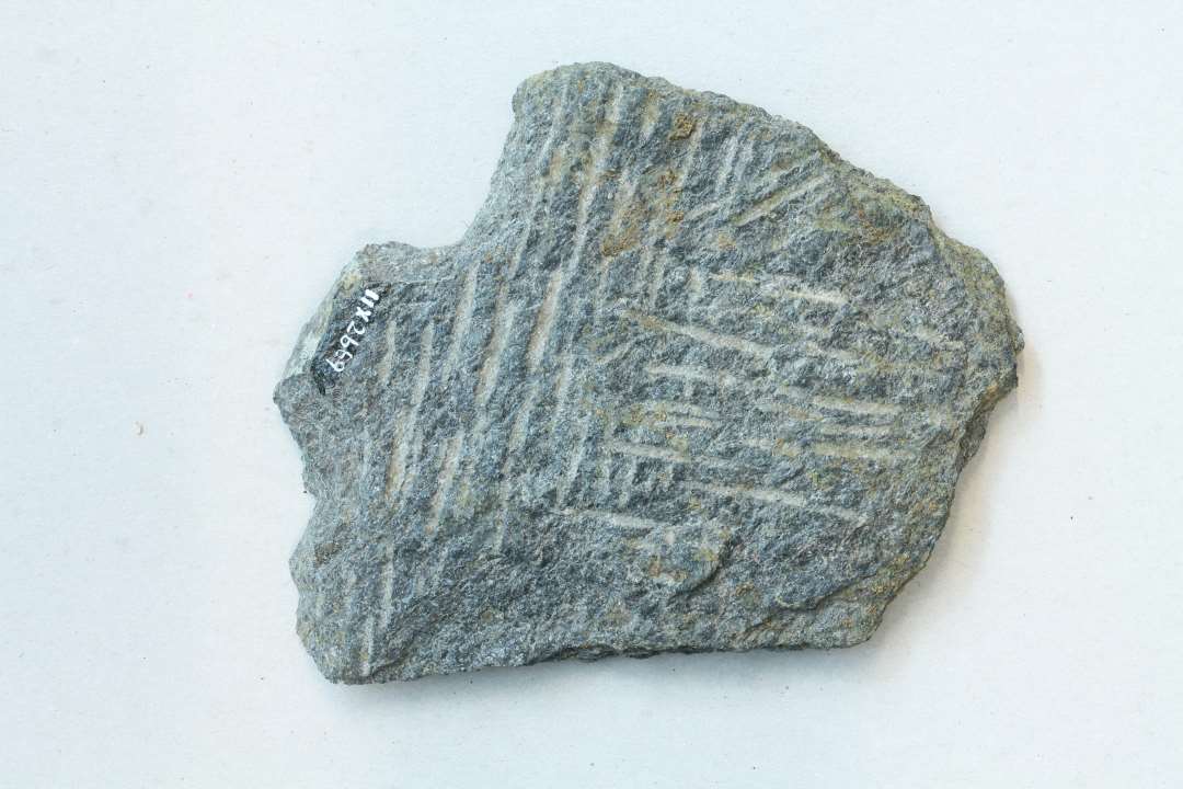 ��Sk�r af bageplade med de karakteristiske mejselhug p� begge sider. M�l: 14,3x12,2 cm., tykkelse: ca 0,5 cm.