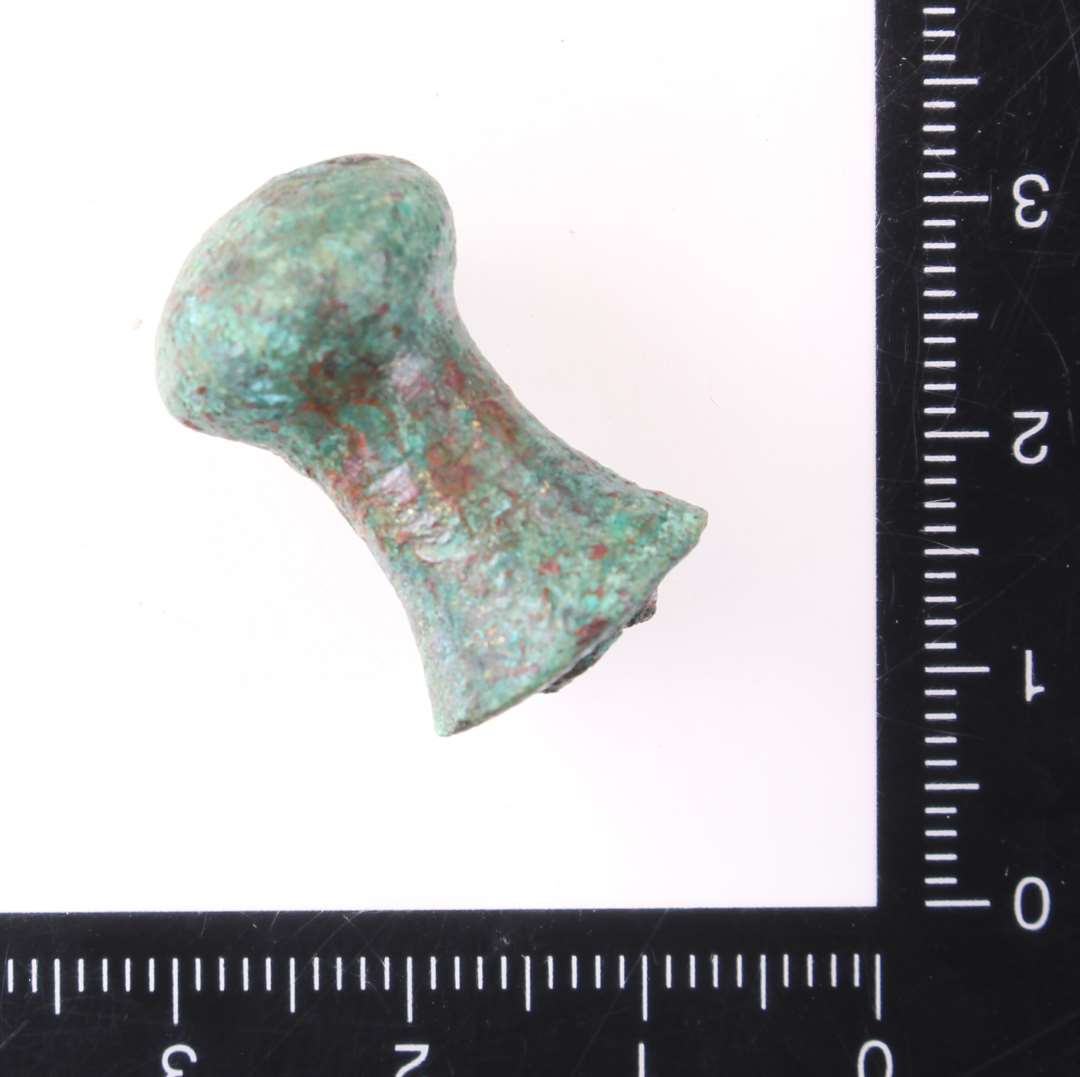 Forgyldt knop, knap eller greb af bronze. Kons.��Af form omtrent som en ludobrik, h�jde 2,4 cm og br�kket forneden. Helt mage til x3224. Sp�ndende genstand. M�ske er det et lille greb fra en skuffe?

Skrinfod