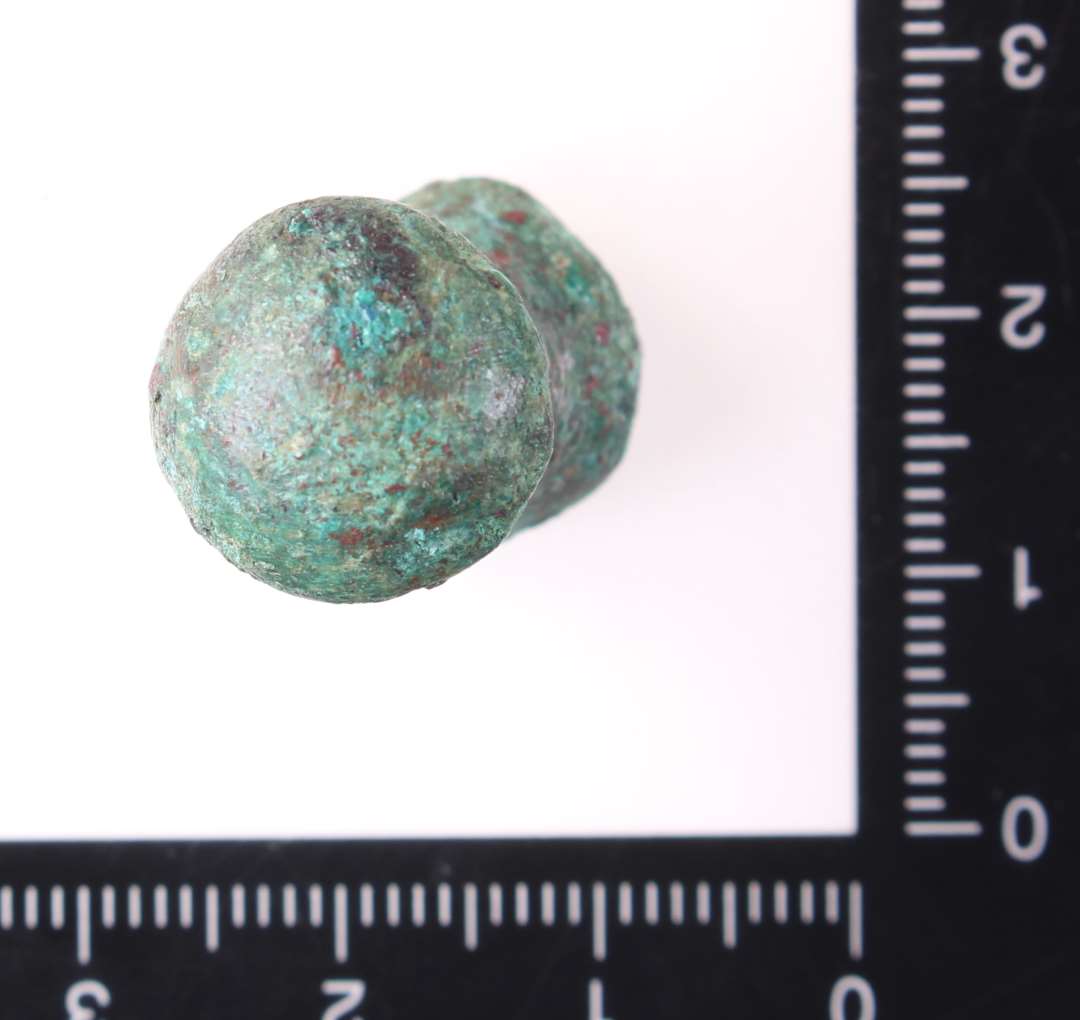 Forgyldt knop, knap eller greb af bronze. Kons.��Af form omtrent som en ludobrik, h�jde 2,4 cm og br�kket forneden. Helt mage til x3224. Sp�ndende genstand. M�ske er det et lille greb fra en skuffe?

Skrinfod