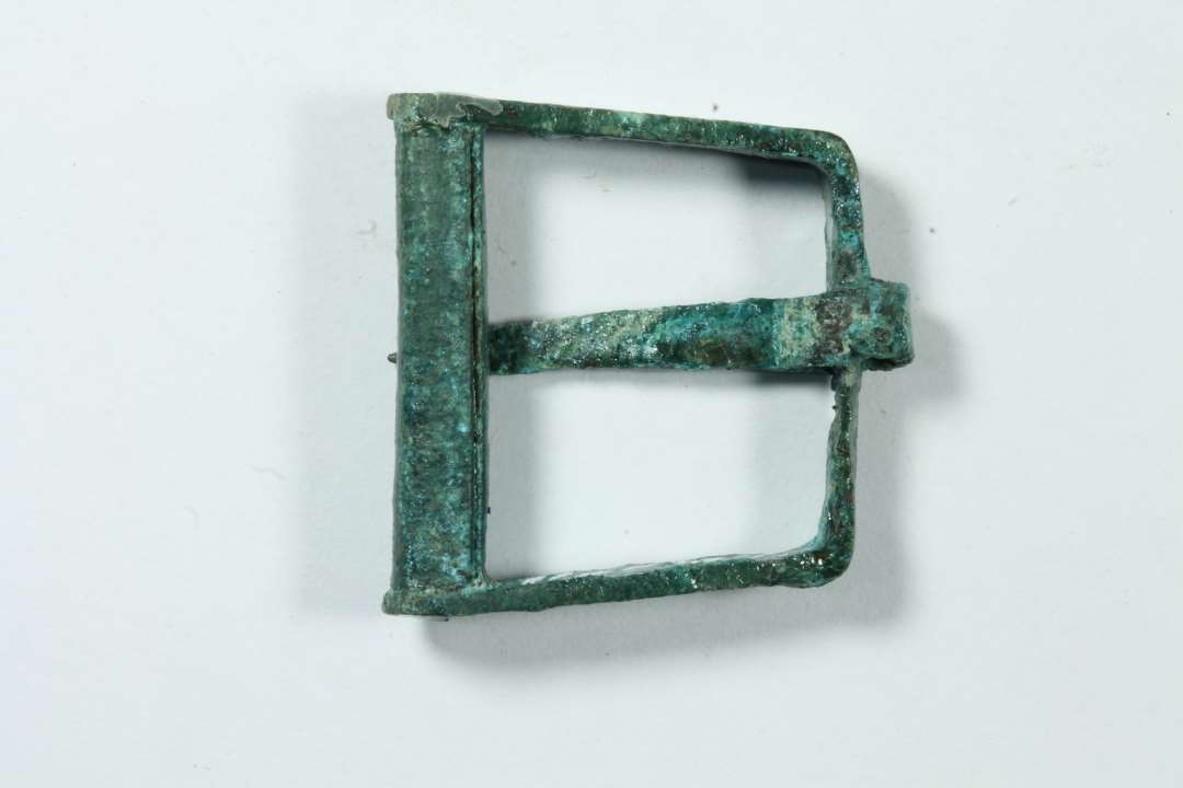 Omtrent kvadratisk sp�nde m. bevaret torn, ikke st�bt, bredde 2,4 cm.