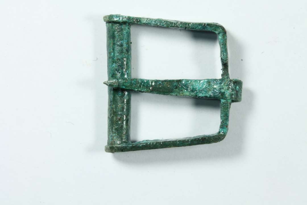 Omtrent kvadratisk sp�nde m. bevaret torn, ikke st�bt, bredde 2,4 cm.