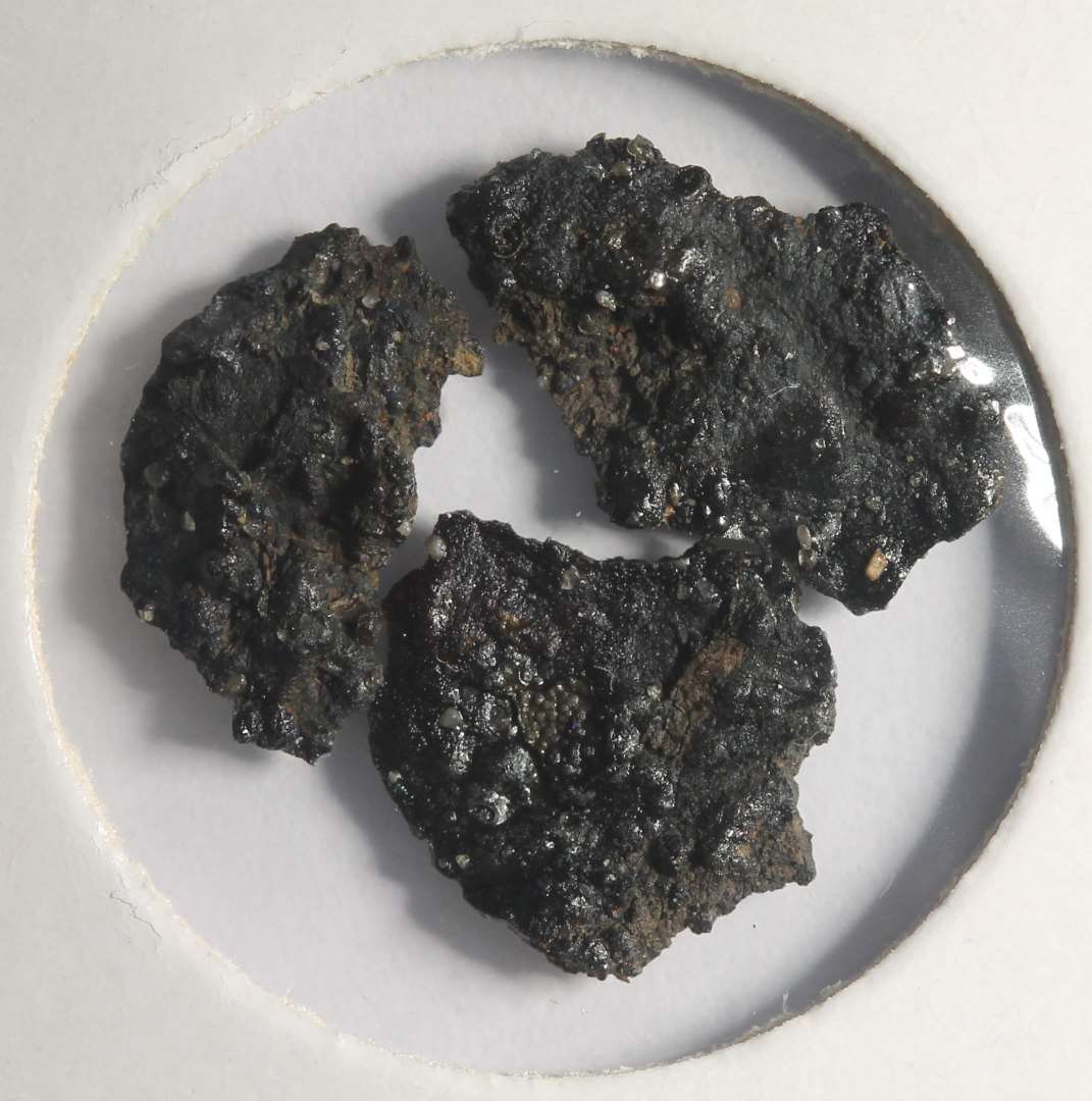 Rx 114: 2 sammenkittede m�nter (m�ntskat!).�Kan p.t. ikke bestemmes. B�r renses (JCM).
Fotos ogs� af korrosionsskaller.
P� den ene m�nt ses stjerne ala MB544 (mfl).

(NM har m�rkv�rdigvis talt m�nterne som fire (146-149). De to af dem er dog korrosionsskaller fra de to egentlige m�nter).

NM 2020:
M�nt, kraftigt korroderet. 