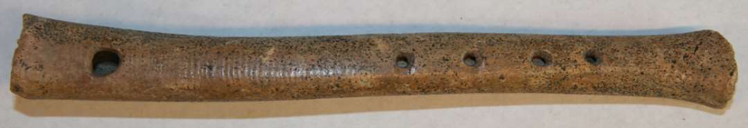 Fl�jte (l: 17 cm.) med 4 fingerhuller og et bl�sehul. Af lammeknogle?