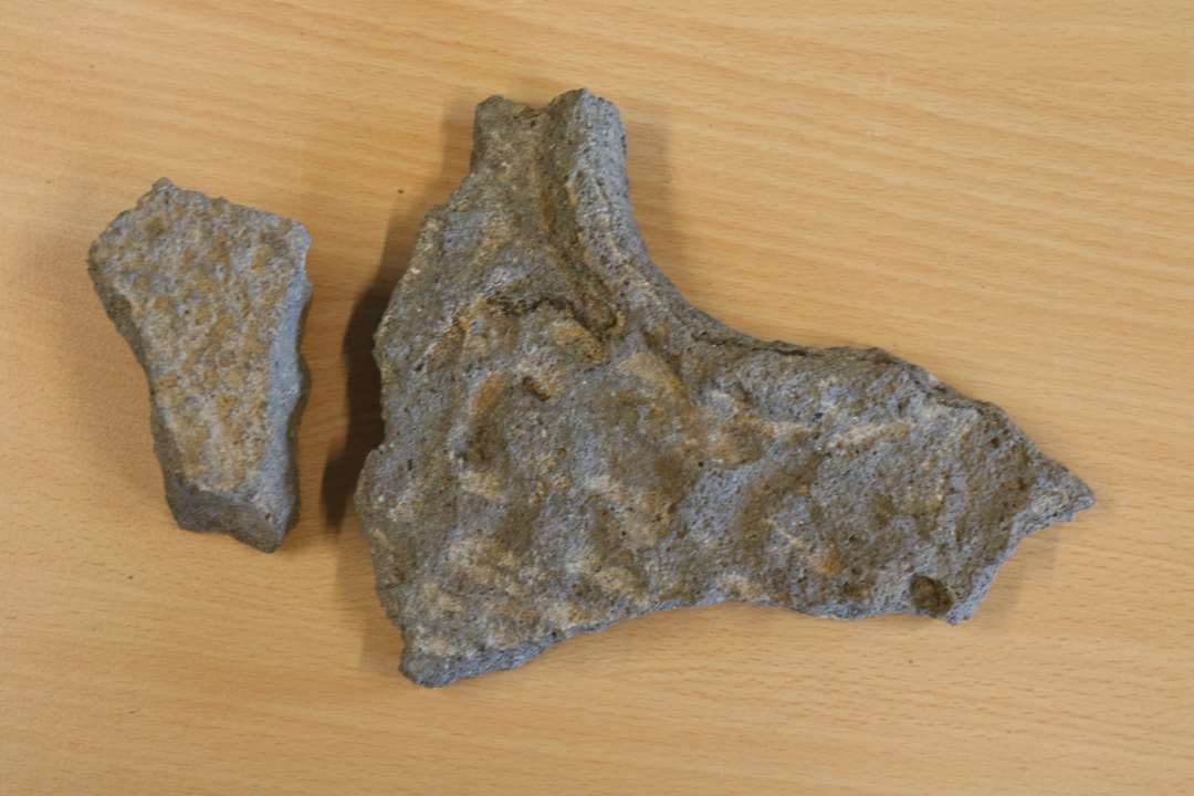 Fragmenter af to forskellige kv�rnsten. Det ene med slibeflade, yderside og midterhul med forh�jet kant. 