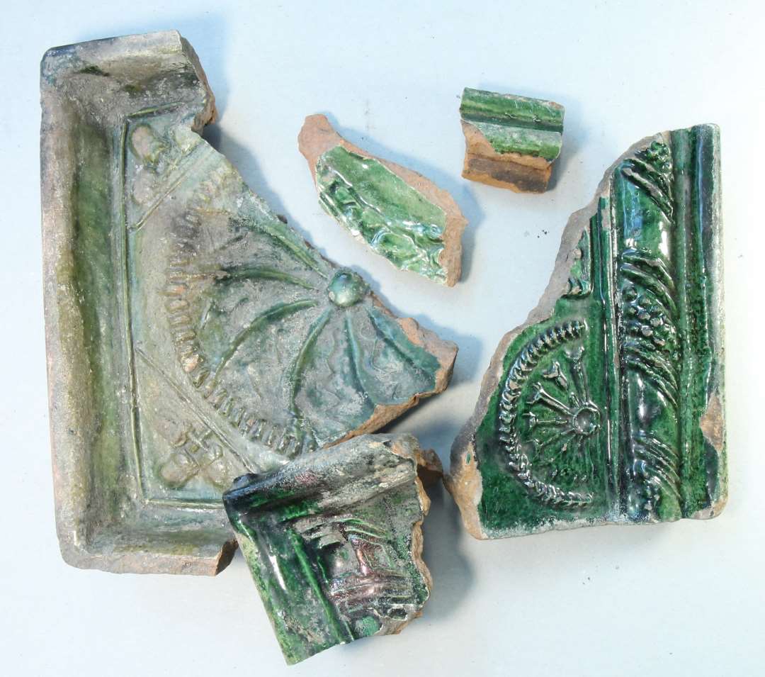 Fragmenter af flere forskellige gr�nglaserede kakler.