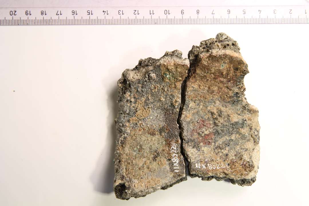 Stort randsk�r (2 sammenh�ngende sk�r) af digel, opr. mundingsdiameter ca. 10 cm. St�rkt sintret ydre, gr�nlig slagge/korrosion indvendig.