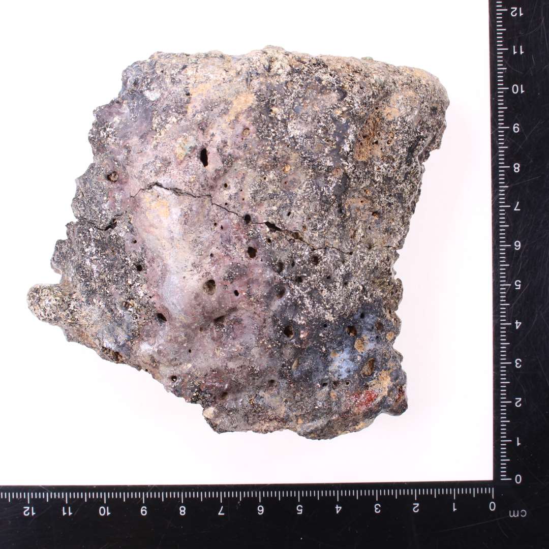 Stort randsk�r (2 sammenh�ngende sk�r) af digel, opr. mundingsdiameter ca. 10 cm. St�rkt sintret ydre, gr�nlig slagge/korrosion indvendig.