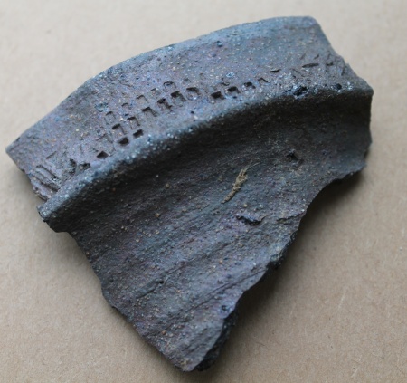 Randsk�r fra n�stenstent�jskande. Oml�bende rullestempling p� randen best�ende skiftevis af tre over hinanden liggende r�kker af rektangler og str� pileformede linjer og trekanter.