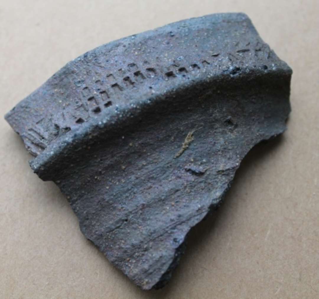 Randsk�r fra n�stenstent�jskande. Oml�bende rullestempling p� randen best�ende skiftevis af tre over hinanden liggende r�kker af rektangler og str� pileformede linjer og trekanter.