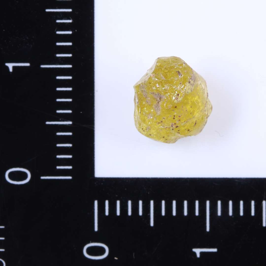 Lille fragmenteret gul glasperle med rester af guld. ??