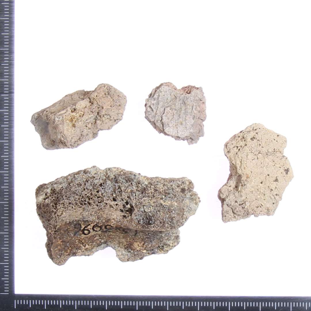 Sammenpresset/br�ndt ler. Et stykke knogle er kittet fast til en af lerklumperne.