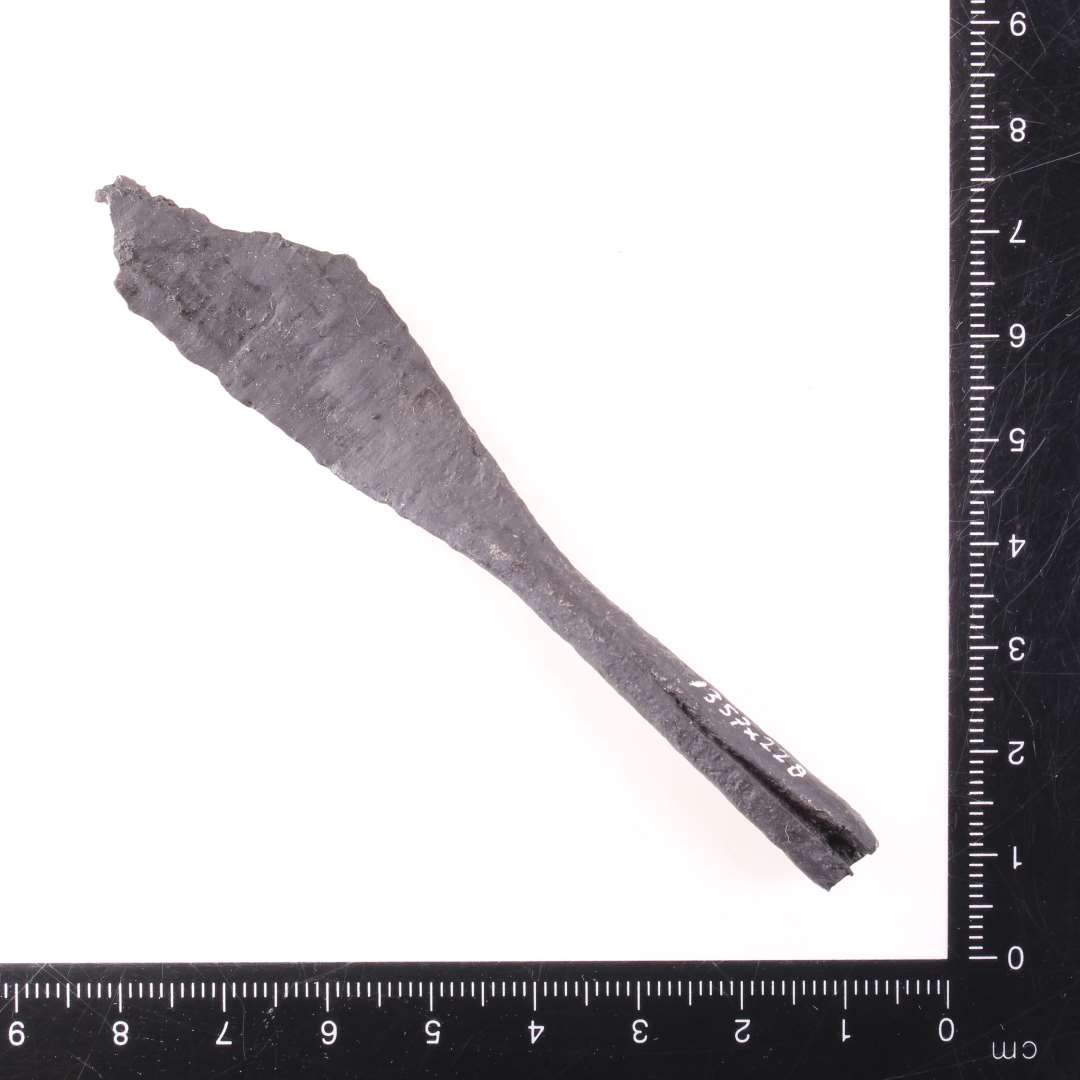 Pilespids med rhombe-formet blad, samt d�lle. Samlet l�ngde 9,5 cm (spidsen ikke bevaret), bredeste sted p� bladet c. 1,7 cm.