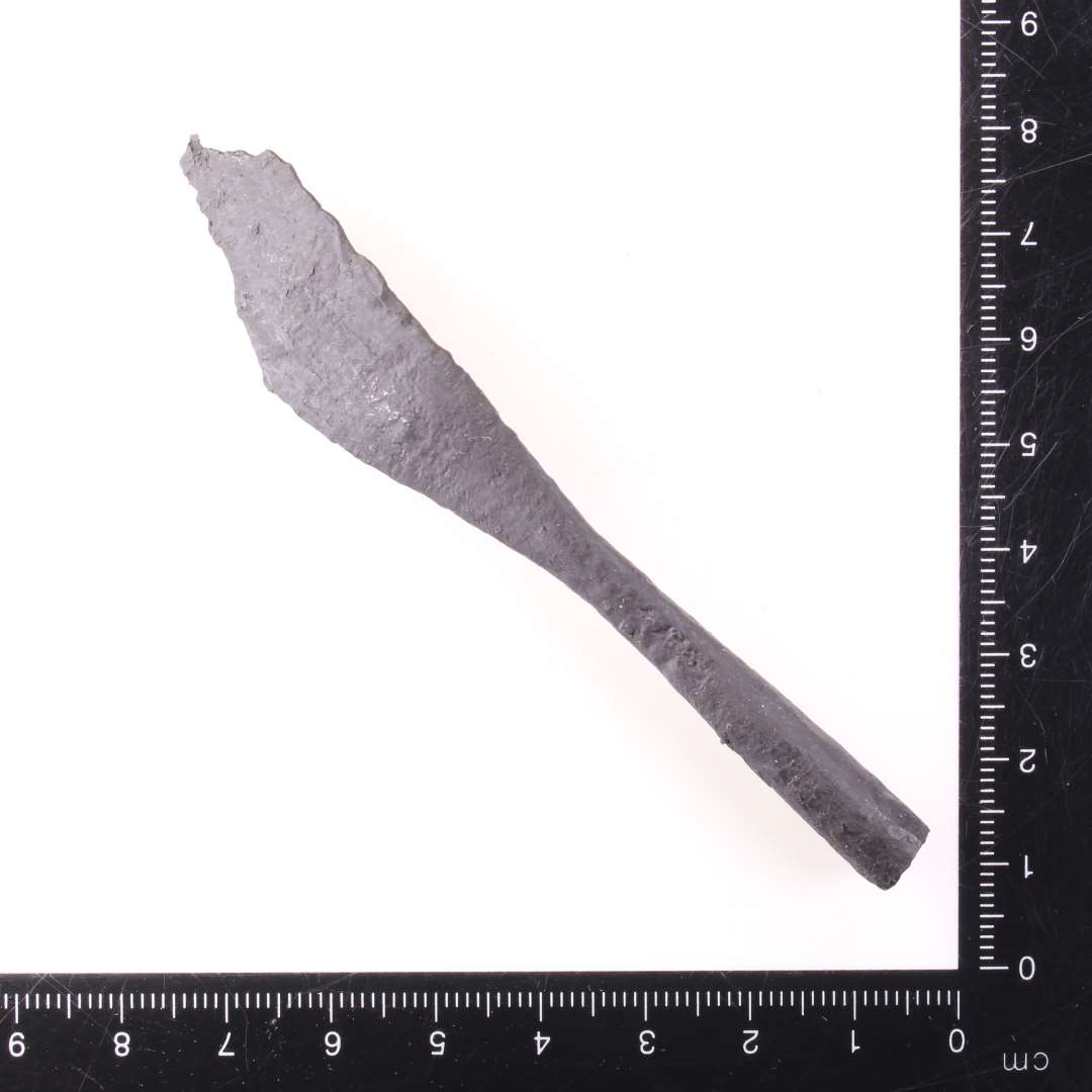 Pilespids med rhombe-formet blad, samt d�lle. Samlet l�ngde 9,5 cm (spidsen ikke bevaret), bredeste sted p� bladet c. 1,7 cm.