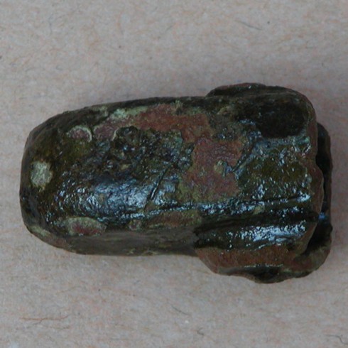 Uident. genstand af bronze. St�bt, ret kraftigt gods, hul. St�rste m�l ca. 2,5 x 1,5 x 1,6 cm.
Hjalte til sv�rd?