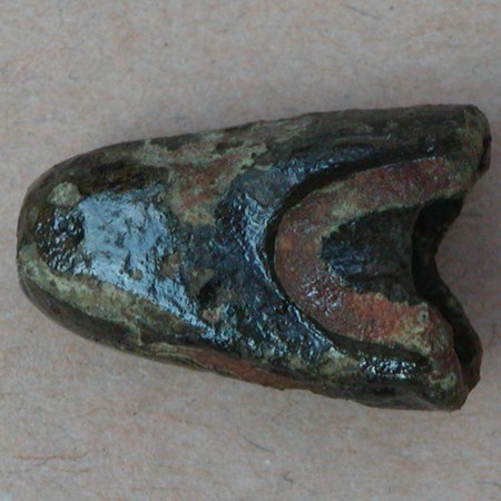 Uident. genstand af bronze. St�bt, ret kraftigt gods, hul. St�rste m�l ca. 2,5 x 1,5 x 1,6 cm.
Hjalte til sv�rd?