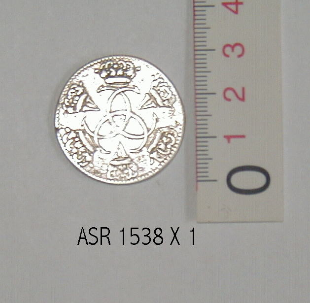 S�lvm�nt
En kopi af en guldm�nt, pr�get i Chr. D V`s tid. 
P� m�ntens forside ses en rytter med en depeche i h�nden. P� bagside er  tre C�r flettet ind i hinanden og i �bningerne i det herved opst�ede m�nster er indflettet romertallet V. Kanten er p� begge side riflet.��
M�ntens diameter 3 cm.�        
Tykkelse 1 mm.��
V�gt: 11,46 g.