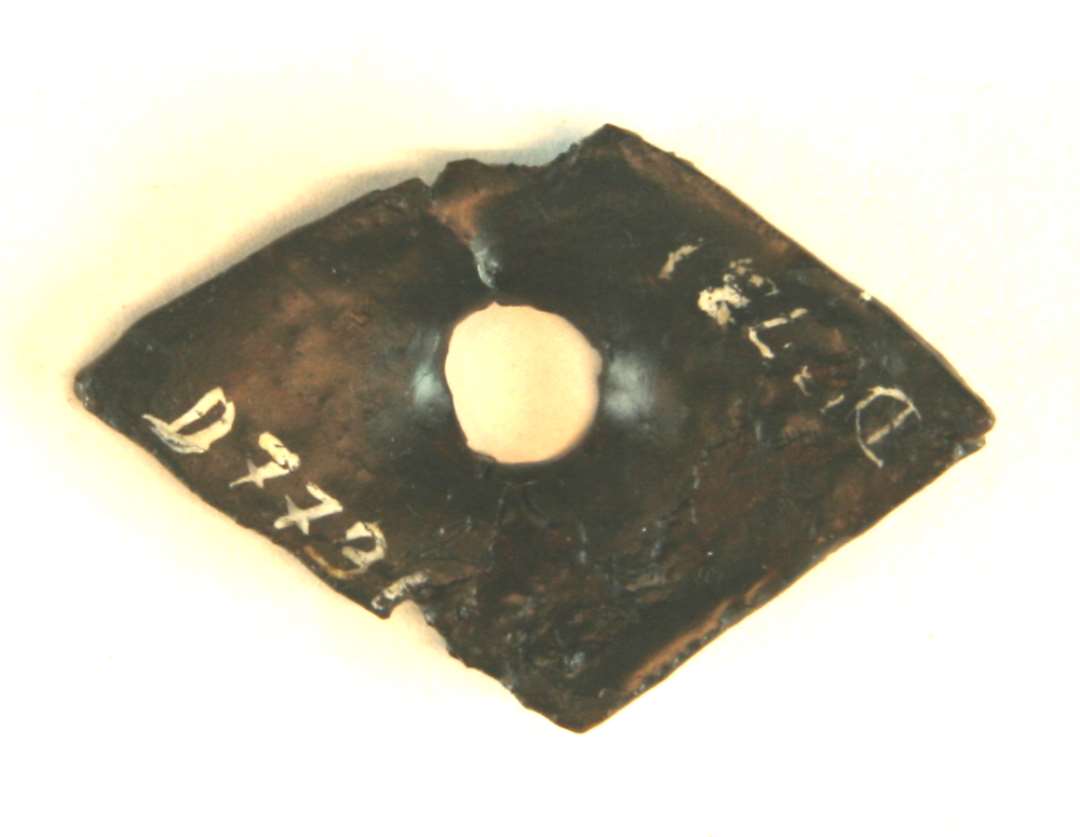 1 afbrudt, rhombeformet klinknaglehoved af jern. 2,8 x 4,3 cm.