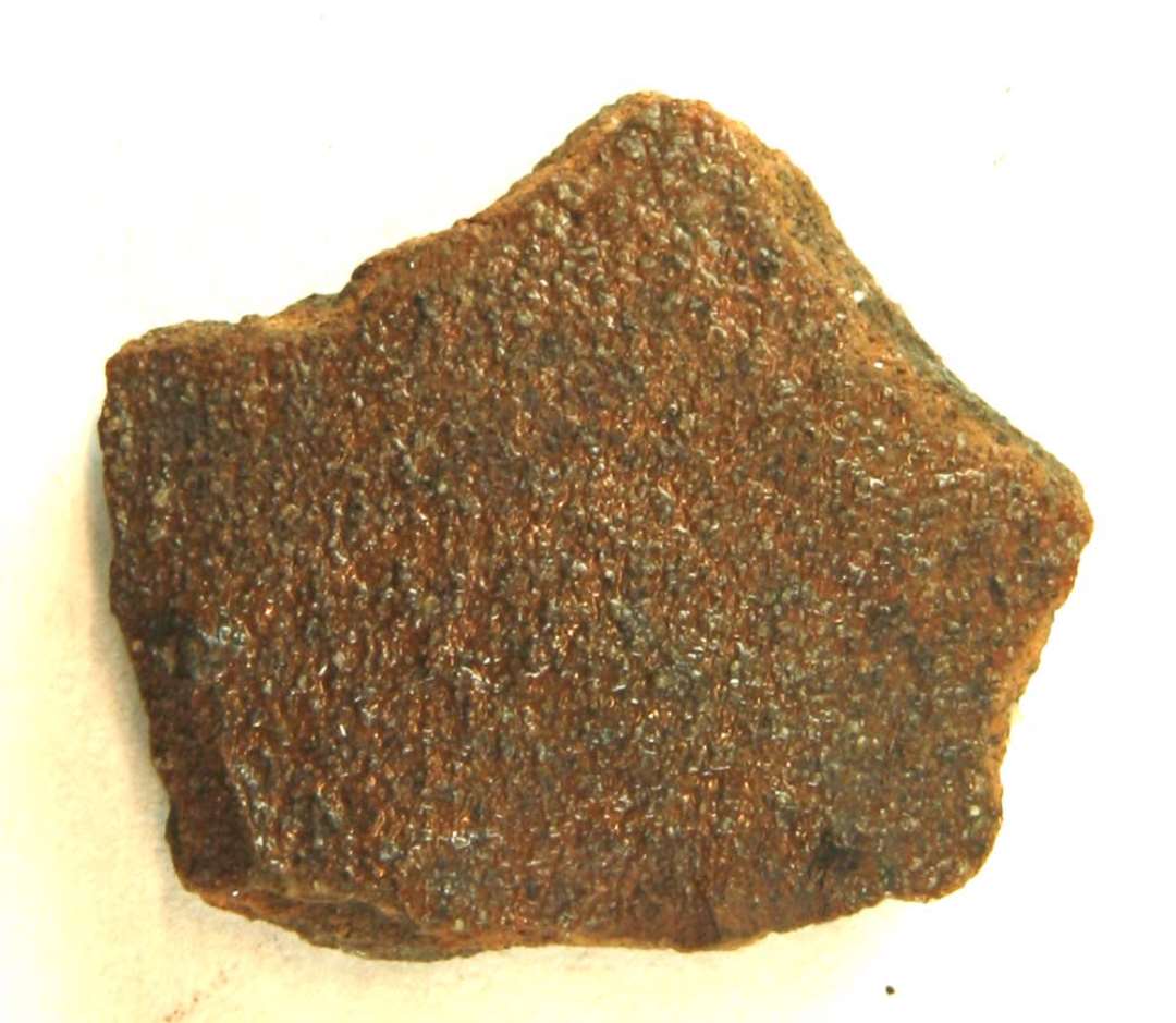 Bugsk�r fra kande af brunligt lergods med svage spor af fingergruber p� ydersiden, der fremtr�der med grynet overflade, d�kket af tynd, klar blyglasur.