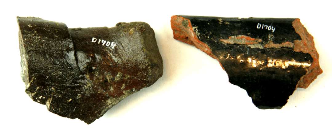 2 stumper fra den overliggende falskant p� vingetagsten af r�dbr�ndt lergods d�kket p� ydersiden med dybsort jernoksyd og blyglasur. Den ene stump er st�rk deformeret ved sintring.