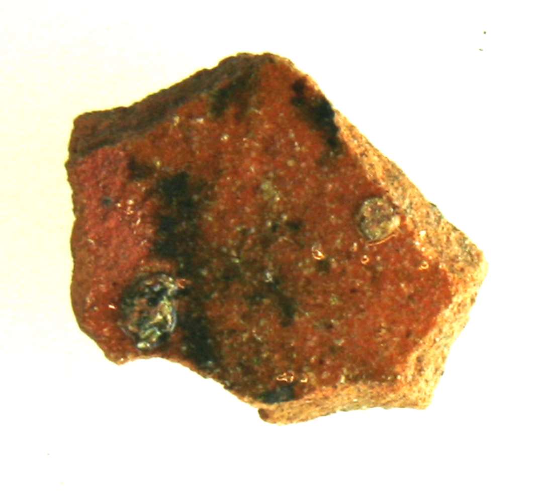 Bugsk�r af r�dbr�ndt kandegods, der p� ydersiden er forsynet med klar blyglasur, hvori enkelte udflydende pletter af jernoksyd.