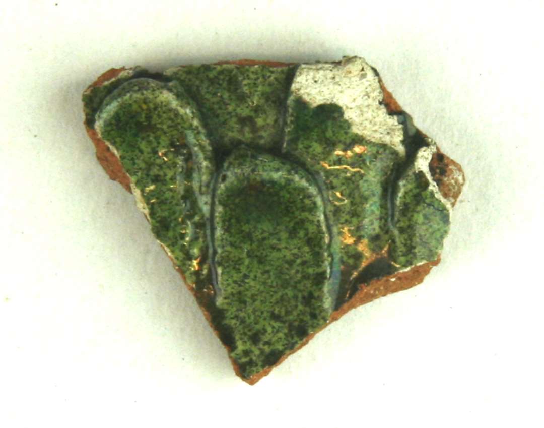 Bugsk�r af r�dbr�ndt, flamsk lergods hvis yderside er forsynet med en bladsk�lsbel�gning af por�st, pibelersagtigt gods, der ligesom indersiden er d�kket af gr�nlig blyglasur.