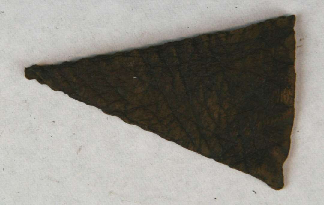 kile af l�der af form som spidsvinklet trekant med syspor langs alle kanter, hidr�rende fra sko eller st�vles sidelukning. St�rste l�ngde: 6,2 cm. St�rste bredde: 4,0 cm.
