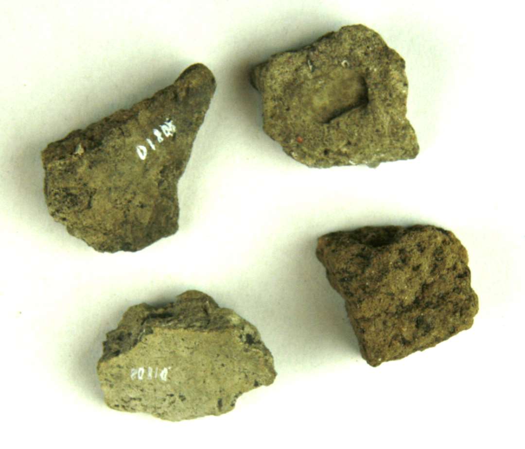 5 stykker br�ndt lerklining hvoraf det ene af st�rrelse som barnen�ve, fremviser lutter brudflader bortset fra en smal uj�vn afglattet flade, de fire �vrige stykker der er af valdn�dsst�rrelse udviser alle een enkelt plan afglattet flade.