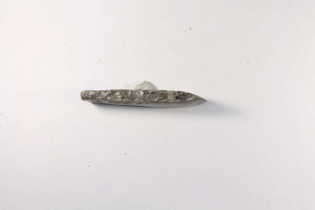 L�ngde 10 cm. St. bredde 2,5 cm. Tyndbladet, tyndnakket, symmetrisk �kse med slebne bred- og smalsider. �ggen velbevaret.��P�malet '9'