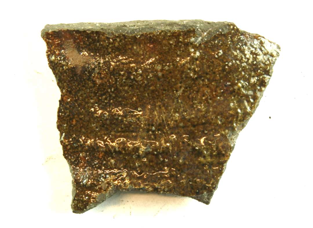 1 sidesk�r af glaseret kande af gr�br�ndt gods med gr�nlig blyglasur p� ydersiden.