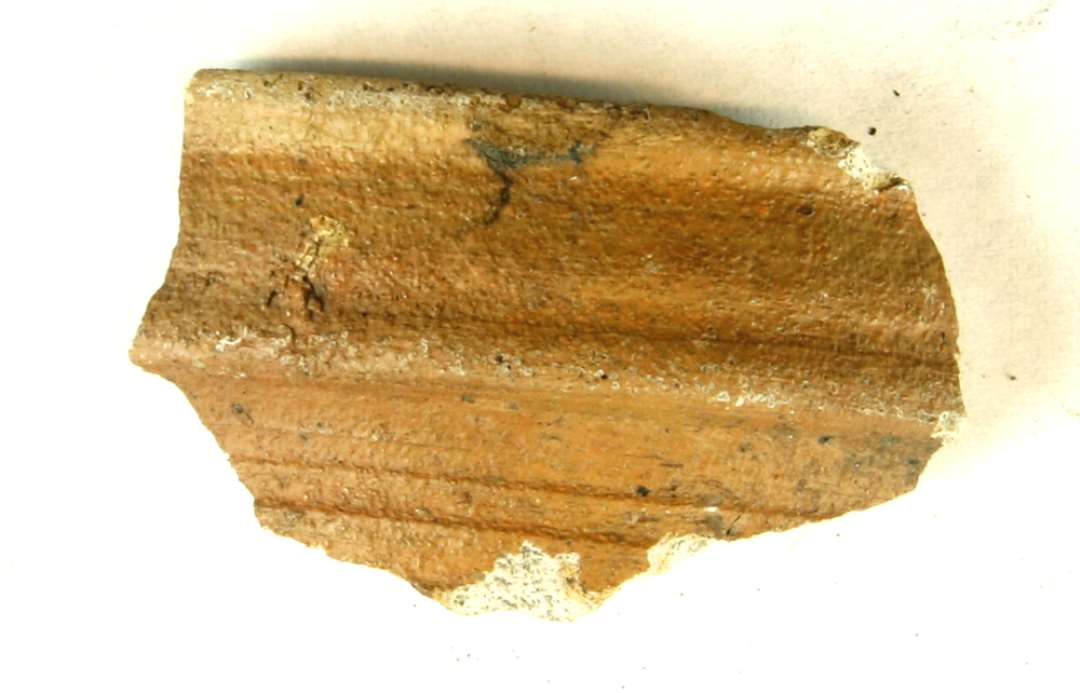 1 mundingsrandsk�r fra stent�jskar af gr�t stent�jsmasse med gulbrune sider. Randen lodret med skarpkantet vulst p� ydersiden.