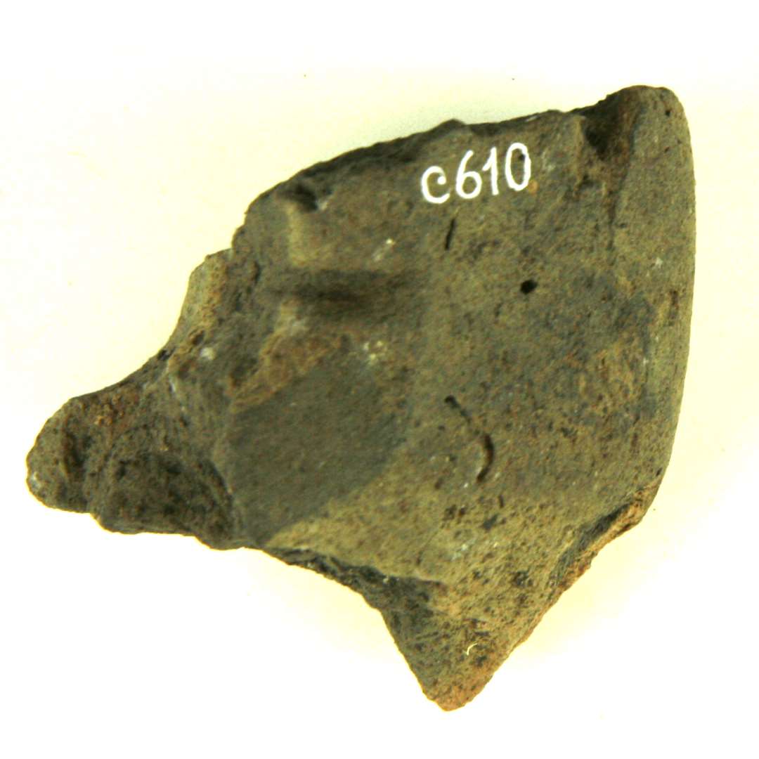 1/5 v�vev�gt af br�ndt ler. Spor af midterhul med rende for garnet i den ene side. St�rste m�l: 6 cm.