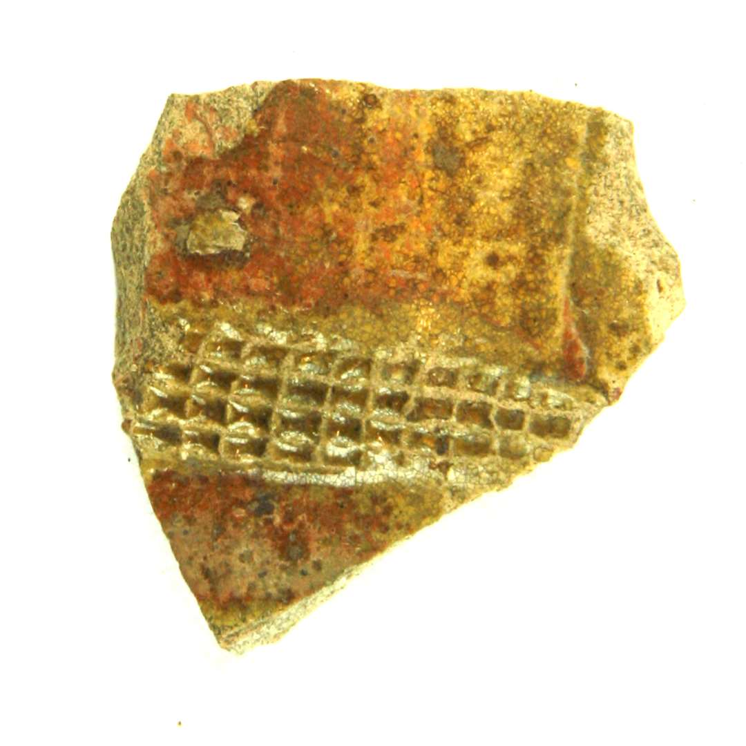 R�d Rouen bug. Af gr�gullig, h�rdtbr�ndt pibelersmasse, p� ydersiden forsynet med et    p�lagt b�nd med indstemplede milimeterstore rektangler. Overfladen omkring b�ndet er d�kket af en noget pletvis anbragt r�dlersbegitning.Hele overfladen er p�f�rt en tynd, klar blyglasur.