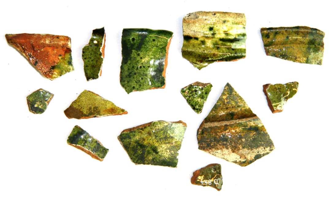 Fire randsk�r, fire halssk�r og fem sidesk�r, alle fra r�dgodskander med pibelersbegitning og gr�nlig blyglasur p� ydersiden, der p� det ene mundingsrandsk�r og halssk�rene tillige har oml�bende furer og vulster.