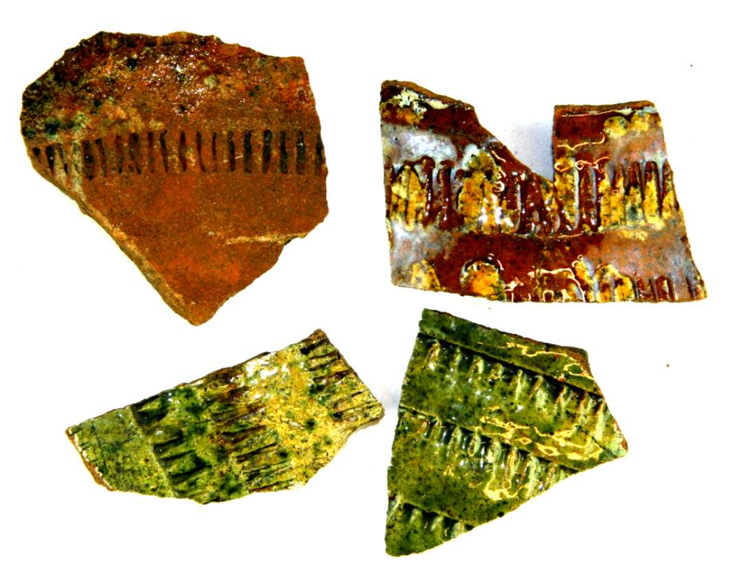 Fire bugsk�r af r�dbr�ndt lergods. Det ene et skuldersk�r med indstemplede stregr�kker anbragt i b�lter med bredt mellemrum, der er d�kket af svag plettet gr�nlig blyglasur.�Endvidere to sk�r med b�lter af indstemplede stregr�kker, d�kket af pibelersbegitning og gr�nligsp�ttet blyglasur samt et sk�r med b�lter af indstemplede stregr�kker, ovenp� hvilke der med mellemrum er anbragt bladsk�l af pibeler, det hele d�kket af klar blyglasur.