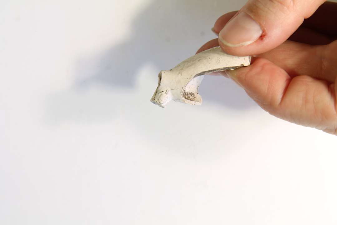 Fragmenteret kridtpibehoved, p� h�len stemplet med et kronet 64, p� siden et rektangul�r, med et ul�seligt stempel hvorover et S