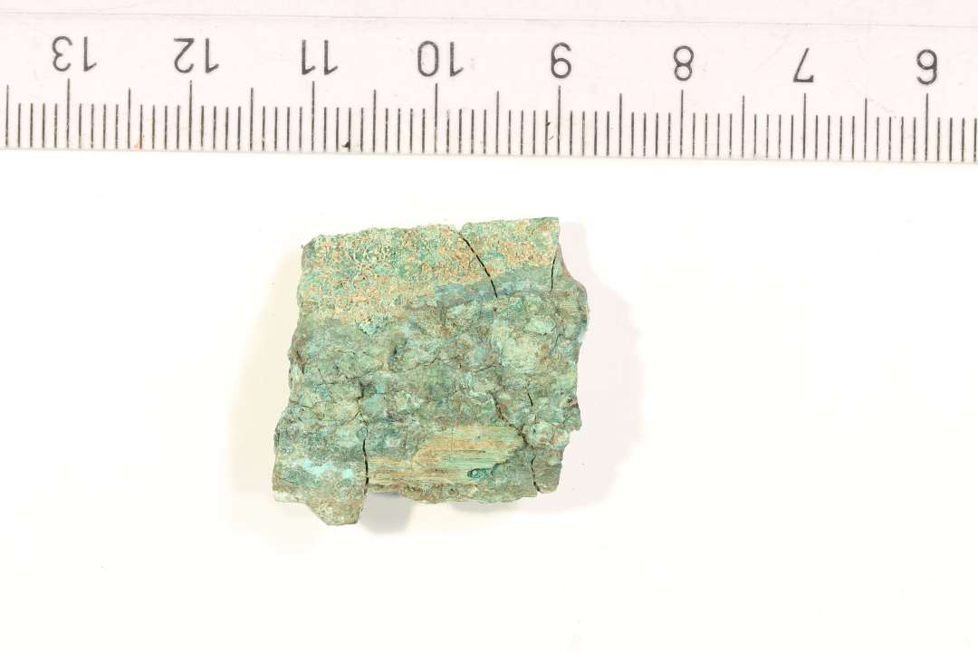 Et 2 x 2 cm. stort fragment af et bronzesv�rd.