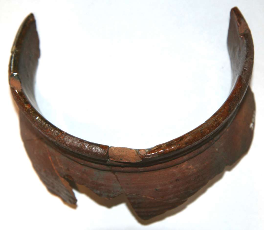 3/4 mundingsrand af brunglaseret stjertpotte. Sammenlimet af flere stykker.