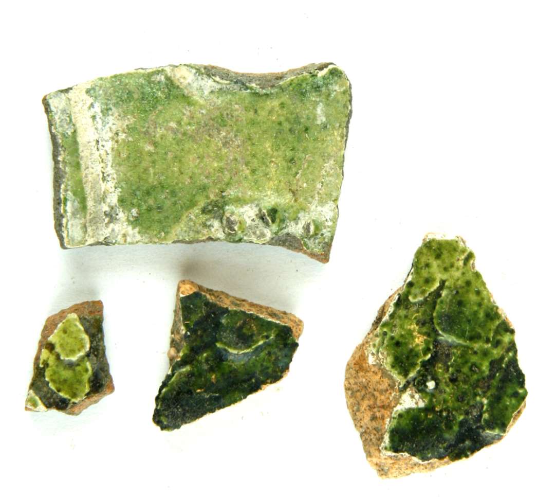 Fire sidesk�r af flamsk keramik, de tre med sk�lbel�gning i pibeler og det fjerde med rest af knoproset i pibeler, alle med gr�n blyglasur.