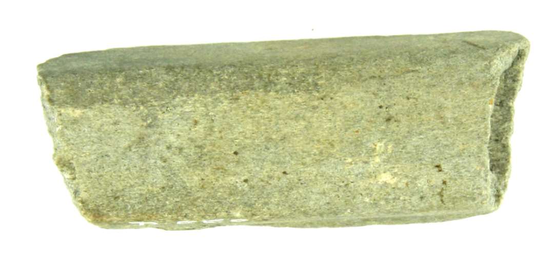 Fragment af en stangformet hv�ssesten af sandsten, glatslebet p� de tre sider, afspaltet p� den fjerde. St�rste l�ngde: ca. 6 cm. 